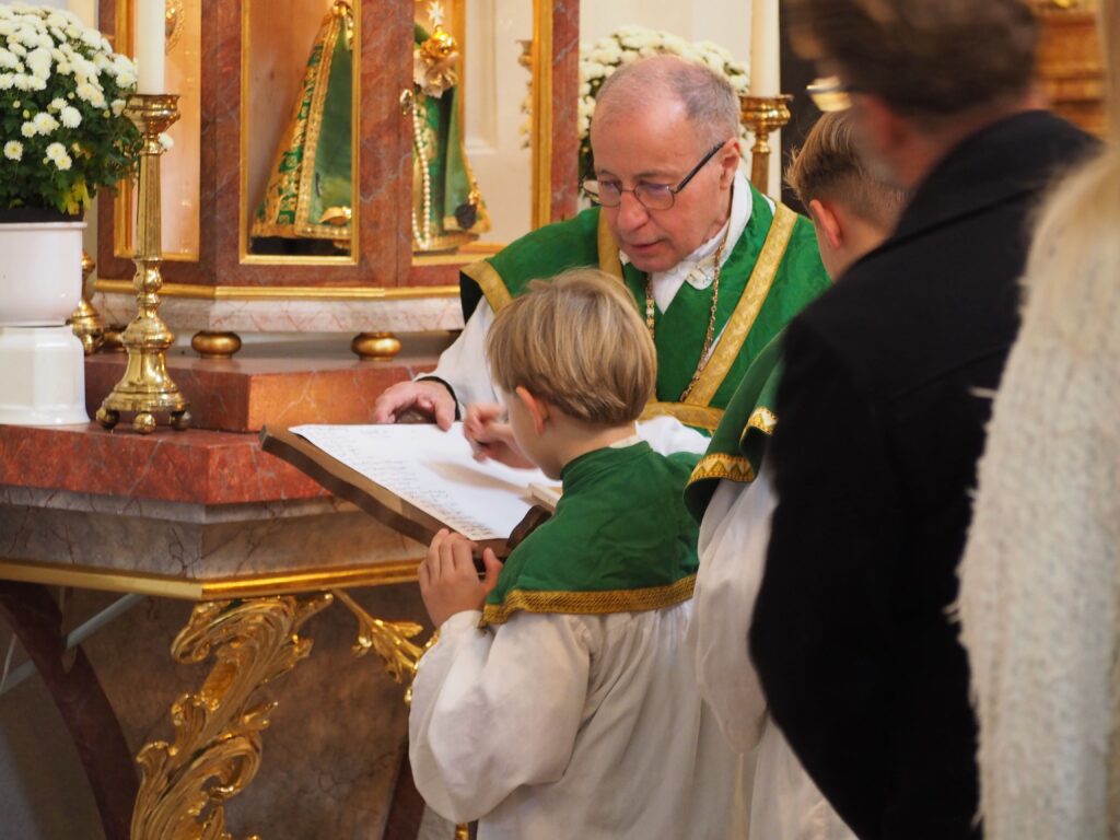 Ministrant unterschreibt auf dem Dokument der Zeitkapsel
